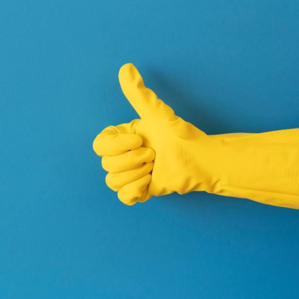 Gelber Reinigungshandschuh mit Daumen hoch – Qualitätsversprechen von Hanna Gebäudeservice in Kassel.